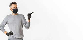 概念冠状病毒生活方式检疫图像中年男人。眼镜医疗面具手套指出手指显示促销横幅站白色背景
