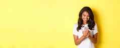 肖像好看的非洲美国女孩白色t恤消息传递智能手机移动电话应用程序站黄色的背景