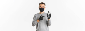概念冠状病毒生活方式检疫有吸引力的中年男人。黑色的医疗面具手套推荐手洗手液指出防腐剂站白色背景