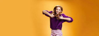 乐观快乐的明亮的姜女孩跳幸福的快乐的有趣的显示拇指批准给积极的反馈超级很酷的的想法概念橙色墙