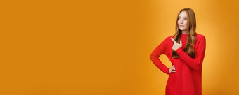 肖像魅力时尚的红色头发的人女企业家设计领先的项目指出上左角落里盯着深思熟虑的集中工作管理业务橙色墙