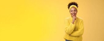 感<strong>兴趣</strong>兴奋热情的好看的女企业家时尚的毛衣头巾非洲式发型发型触碰下巴深思熟虑的微笑喜欢项目的想法站黄色的背景感<strong>兴趣</strong>