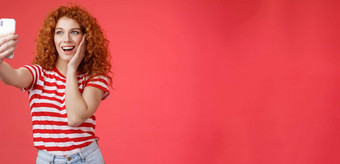 时尚可爱的红色头发的人卷曲的女夏天t恤记录视频社会媒体奢侈品热带resolt旅行假期在国外自拍持有智能手机构成愚蠢的照片红色的背景