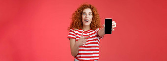 太棒了智能手机深刻的印象兴奋好看的女爱数字创新红色头发的人女孩卷曲的发型显示电话屏幕指出显示促进很酷的应用程序