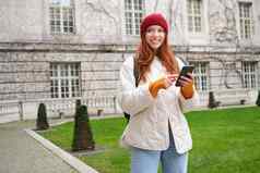 肖像女孩旅游奇迹城市智能手机地图应用程序持有移动电话微笑信息互联网