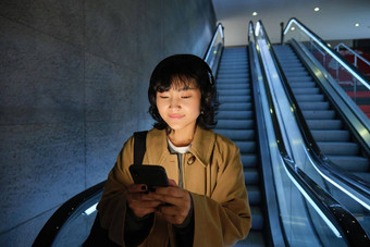 可爱的年轻的女人自动扶梯管<strong>地铁地铁上</strong>下班工作大学站智能手机