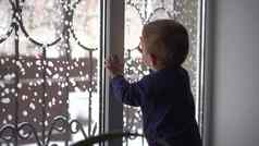 小孩子站窗台上窗口孩子敲门玻璃冬天