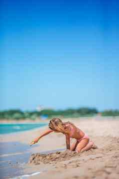 可爱的女孩玩海滩玩具热带假期