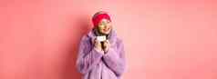购物时尚概念时尚亚洲女人紫色的人造皮毛外套快乐显示塑料信贷卡微笑快乐的站粉红色的背景