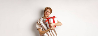 情人节一天假期概念快乐红色头发的人男人。拥抱礼物盒子感谢相机兴奋感激的白色背景