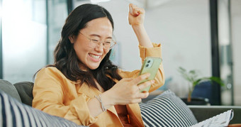 业务女人电话成功拳头工作办公室沙发数字市场营销启动亚洲广告公司微笑快乐赢家有创意的设计师移动技术欢呼目标