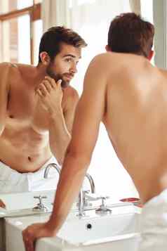早....例程赤膊上阵年轻的男人。检查皮肤浴室镜子