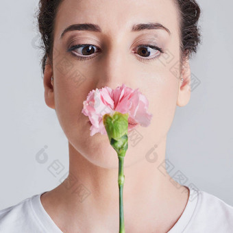 花<strong>花朵</strong>时间工作室拍摄美丽的年轻的女人闻粉红色的花<strong>灰色背景</strong>