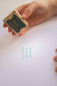 女人的手把邮票可持续发展的包装