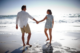 享受闷热的萨默斯一天后视镜快乐成熟的夫妇走手手海滩