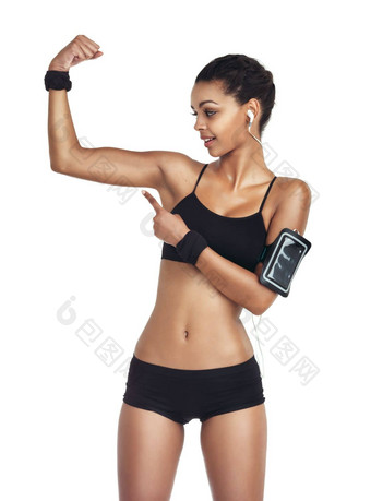 工作室强大的手臂黑色的女人指出健美运动员培训健康锻炼健康锻炼结果听音乐广播播客健身模型孤立的白色背景