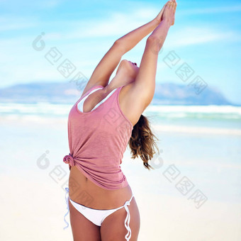 <strong>拉伸</strong>潜在的年轻的女人瑜伽海滩