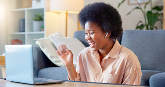 年轻的女人视频调用移动PC坐着<strong>首页首页无线</strong>耳机快乐的美丽的非洲美国女非洲式发型会说话的朋友在线闲谈，聊天应用程序