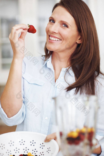 不能抵制有吸引力的女人吃草莓准备奶昔