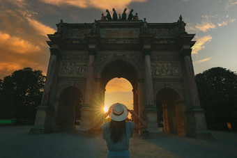 年轻的女人旅游太阳他站前面凯旋拱旋转木马巴黎日落旅行法国旅游概念