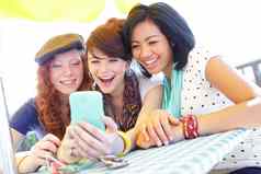 伟大的照片集团青少年女孩笑智能手机屏幕