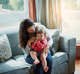 放松快乐微笑妈妈。婴儿沙发成键质量时间孩子发展增长支持信任妈妈女儿家庭首页健康连接护理