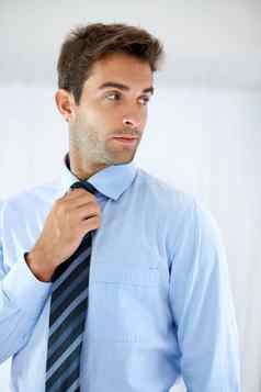雄纠纠的通常英俊的商人站窥视肩膀调整领带