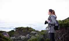 搜索天空风景年轻的女人双筒望远镜徒步旅行