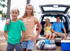 家庭享受假期肖像年轻的哥哥妹妹享受假期父母坐着回来车