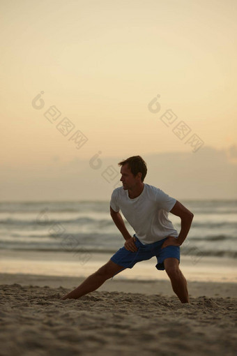 伸展运动海男人。<strong>瑜伽</strong>海滩日落