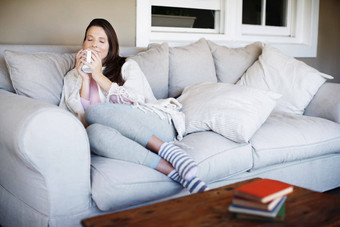 品味杯咖啡肖像有吸引力的女人享受杯咖啡躺沙发在室内