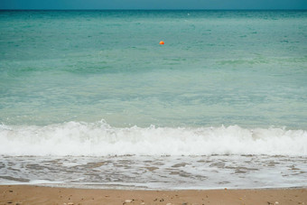 阴天空多雨的一天泡沫波滚动金沙子海滩低温暖的太阳光假期娱乐概念摘要航海夏天海洋日落自然