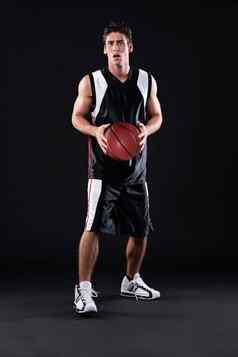 他真正的运动员完整的长度拍摄篮球球员站球黑色的背景