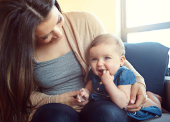 放松快乐微笑妈妈。婴儿沙发成键质量时间孩子发展增长支持信任妈妈女儿家庭首页健康连接护理