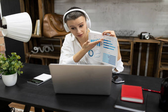 强大的成熟的高加索人女商人短发型持有在线会议耳机展示<strong>图</strong>移动PC屏幕