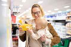 高加索人妈妈。购物婴儿婴儿男孩孩子选择产品部门超市杂货店商店
