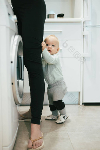 婴儿婴儿男孩孩子隐藏母亲腿要求注意多任务处理家庭家务厨房首页妈妈。<strong>孕妇</strong>离开