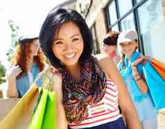 出售季节美丽的少数民族女孩持有购物袋微笑朋友背景
