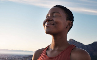 健身平静呼吸黑色的女人户外自然山蓝色的天空背景瑜伽健康冥想Zen能源脸女孩呼吸和平自由正念