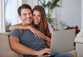 连接肖像充满深情的年轻的夫妇坐着移动PC首页