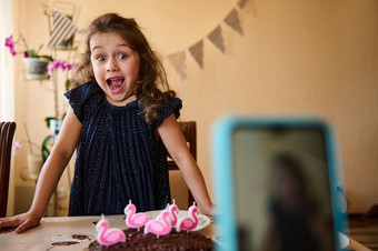 智能手机模糊前景记录视频生日女孩海军衣服吹蜡烛节日蛋糕