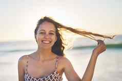 风头发微笑脸年轻的女人享受一天海滩