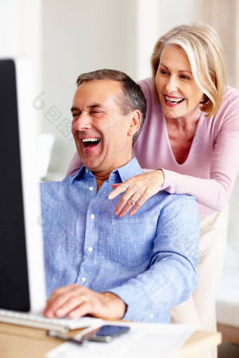 快乐的成熟的男人。妻子工作电脑肖像快乐的成熟的男人。妻子工作电脑