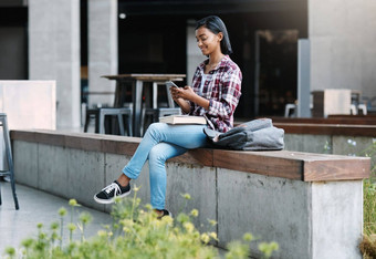 发短信校园完整的长度拍摄有吸引力的年轻的女学生手机坐着校园