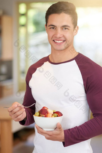 开始一天健康的肖像快乐年轻的男人。享受健康的早餐水果厨房首页