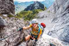 微笑高加索人女人登山者太阳镜铁索攀岩小道阿尔卑斯山脉阳光明媚的夏天一天