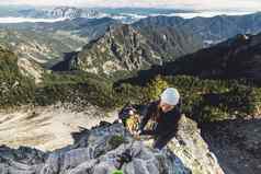 风景优美的视图山女人登山者铁索攀岩小道阿尔卑斯山脉阳光明媚的秋天一天