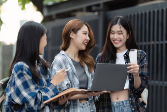 美丽的年轻的亚洲女人大学学生朋友在户外大学学生工作大学校园