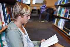 勤奋支付决赛年轻的大学学生坐着地板上图书馆阅读