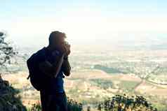 捕捉世界后视图拍摄年轻的男人。采取照片风景优美的视图前山